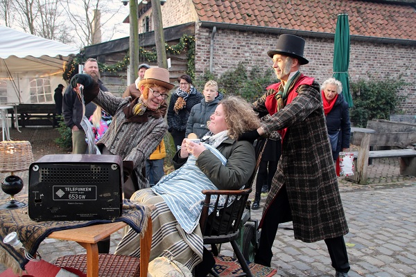 Verklede vrijwilligers lopen een optocht in Openluchtmuseum Eynderhoof in de stijl van de tijd van Anton Pieck