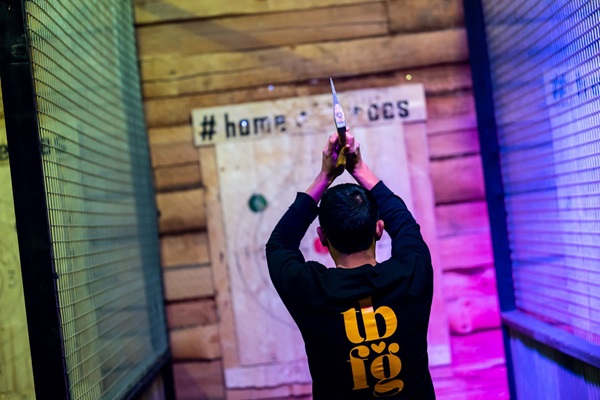 Man bereidt zich voor om een bijl te werpen naar een houten doelwand bij Home of Heroes in Buggenum.