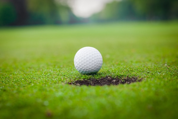 Golfbal ligt op de rand van de hole