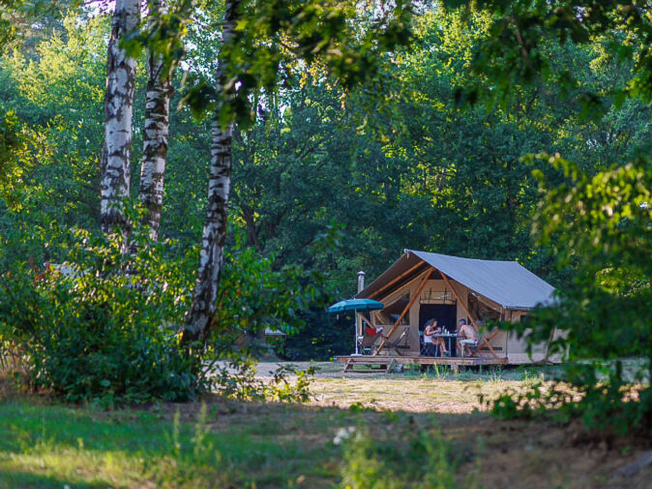 Twee mensen zitten voor een chalet in het bos
