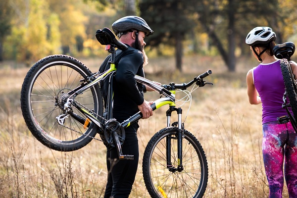 Mountainbiker heeft zijn mountainbike gepakt en loopt door het landschap