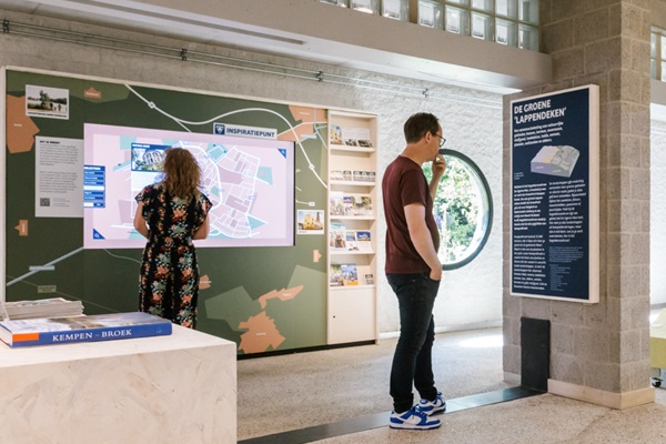 Vrouw kijkt op de inspiratiewand van VVV-inspiratiepunt NMC Weert