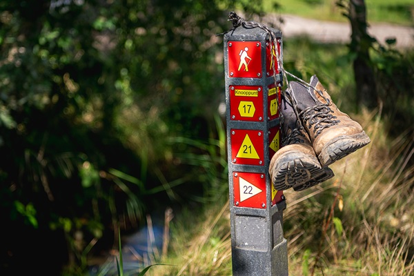 Hiking shoes hang from a route post in Roermond municipality