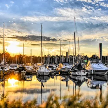 Jachthaven De Spaanjerd bij zonsondergang, met aangemeerde boten en rustige waterreflecties.