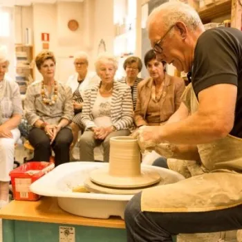 Man geeft een pottenbakdemonstratie aan een groep bezoekers tijdens een workshop in de Tiendschuur in Tegelen.
